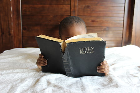 child-reading-bible-bed-thumb